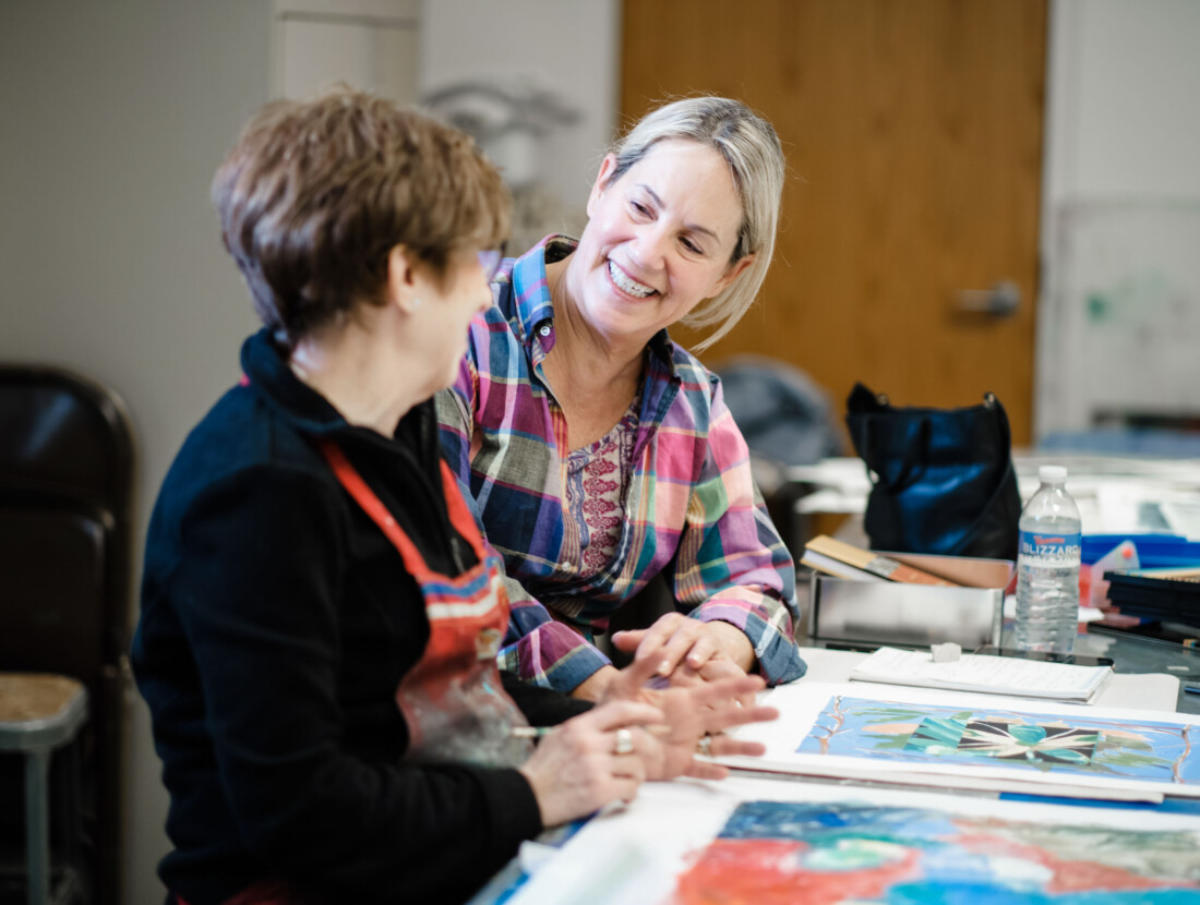 An art class instructor helping a student.