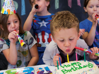 Children blowing out candles at a birthday party.