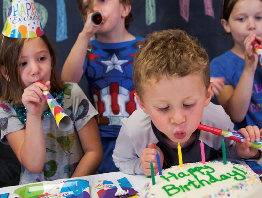 Children blowing out candles at a birthday party.