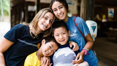 Kids with their counselors smiling at Camp Grossman.