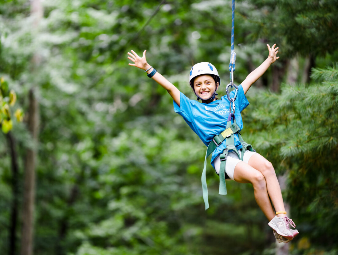 A camper riding a zipline.