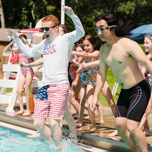 Counselors jumping in the pool.