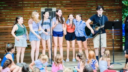 Group of girls putting on a musical performance outdoors.