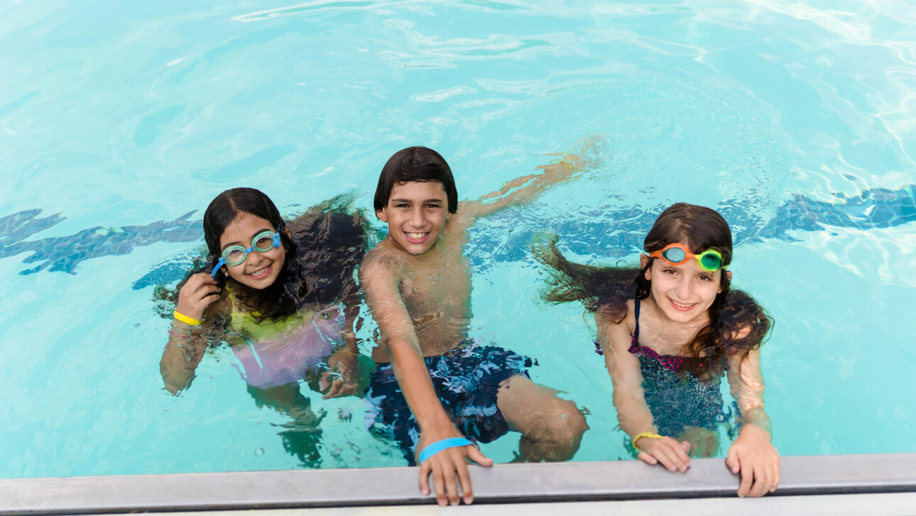 Three children in an outdoor pool.