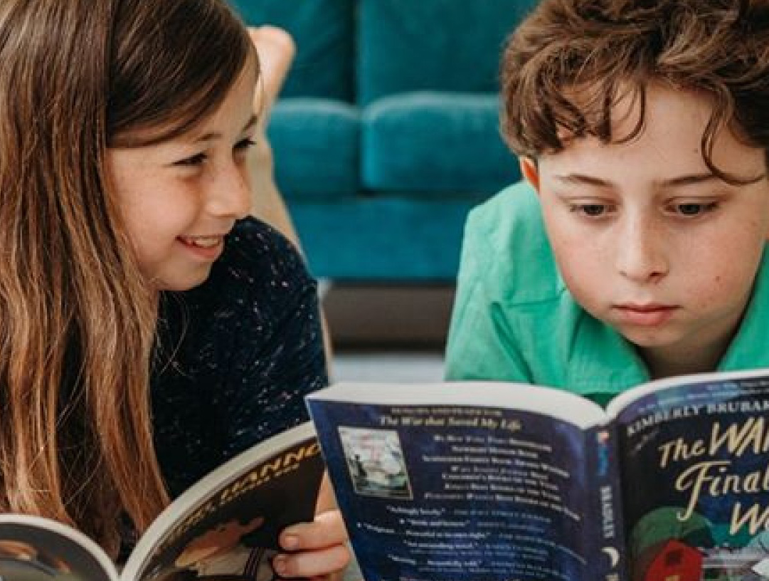 Two kids reading books.