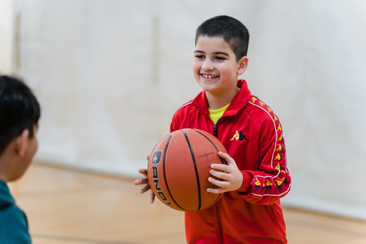 Boy smiling with a basketball.