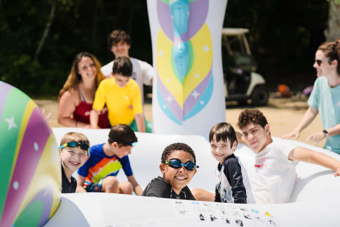 Kids on a water float at Camp Grossman.