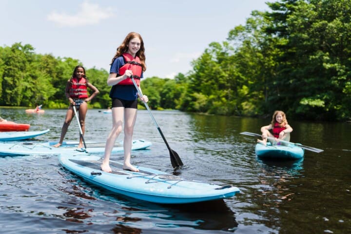 Girls posing on paddleboard.