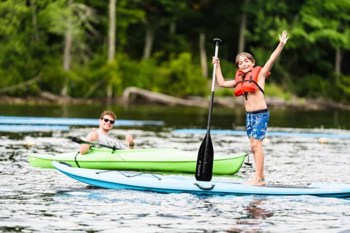 Kids posing on paddleboard.