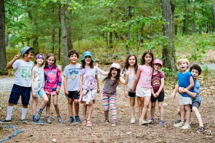 Kids smiling in the woods at Camp Grossman.