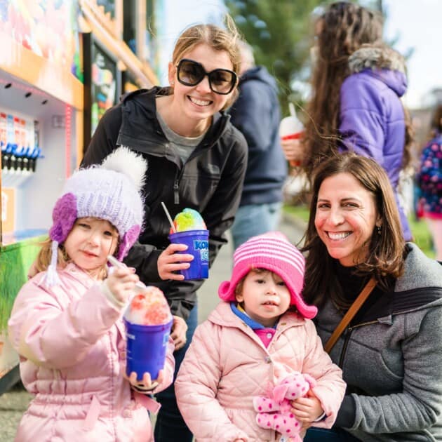 Family eating shaved ice outdoors.