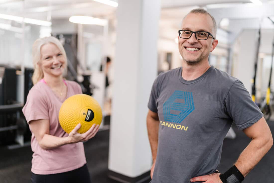 A man and a women posing with a weighted ball.