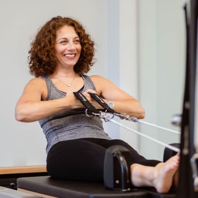 Woman using a pilates reformer.