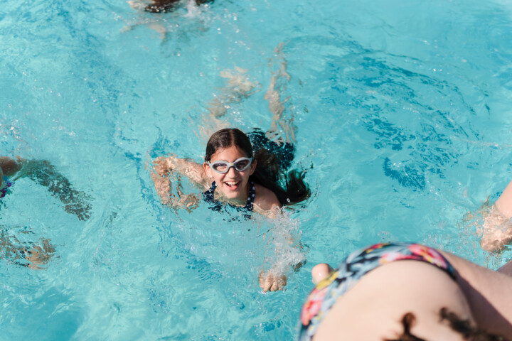 Girl smiling in a pool.