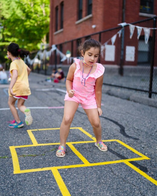 Girl playing hop scotch.