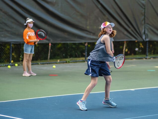 A girl playing tennis at Tennis Camp.