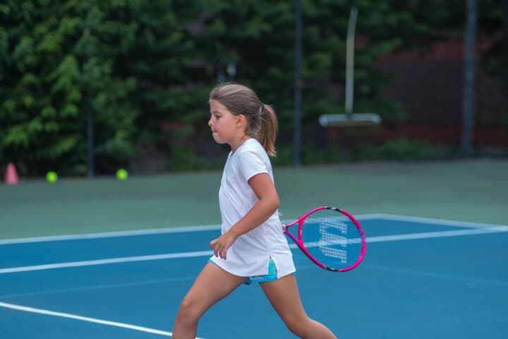 A girl playing tennis.