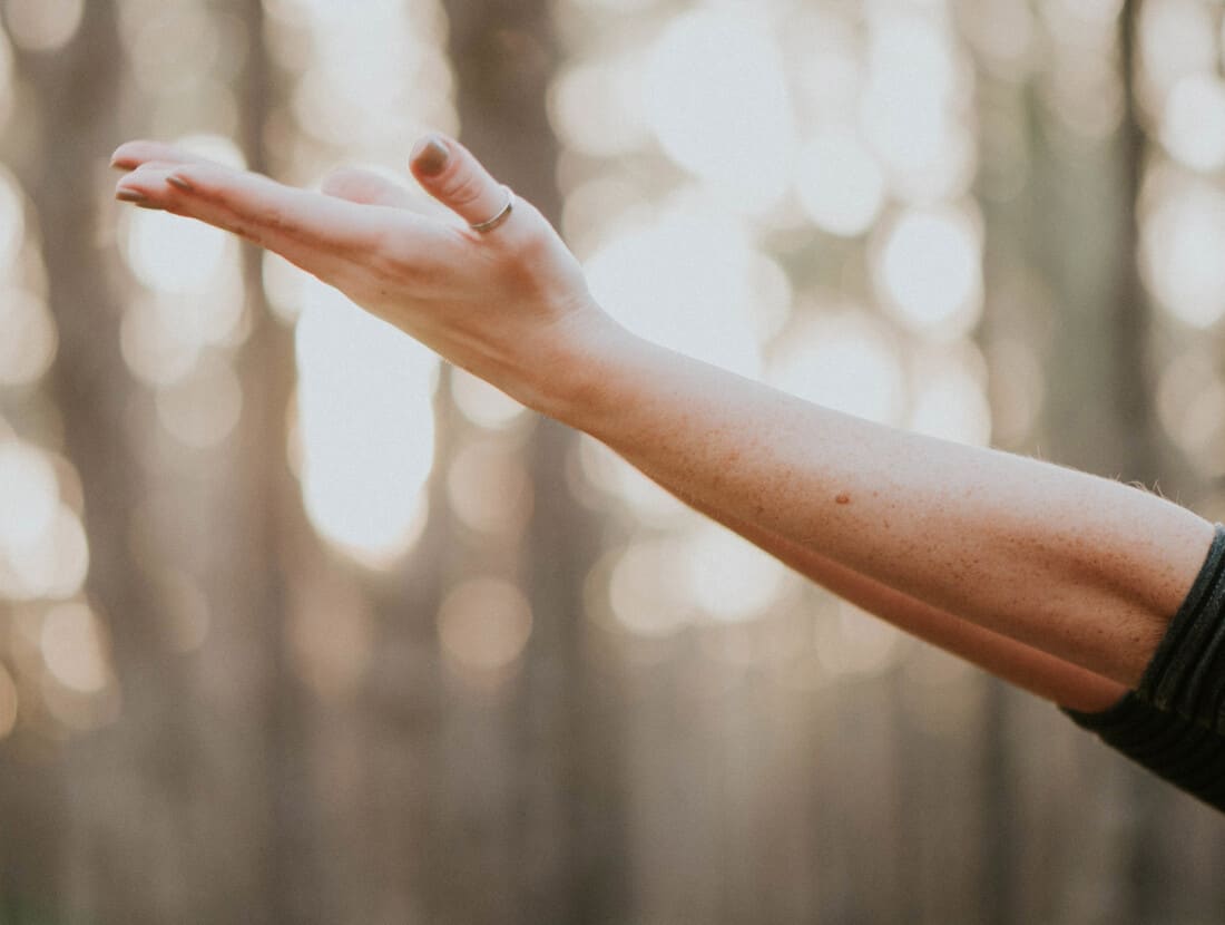 A person stretching their arm towards the sky.