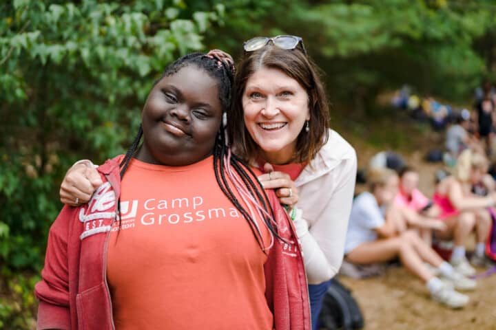 Girl smiling with a staff member at Camp Grossman.