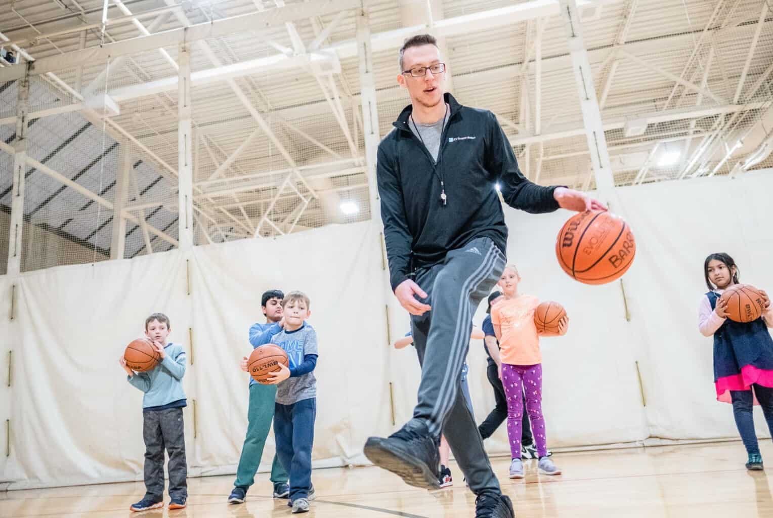 Kids taking a basketball class.