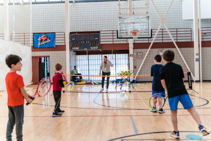 Kids playing tennis indoors at JCC Greater Boston.