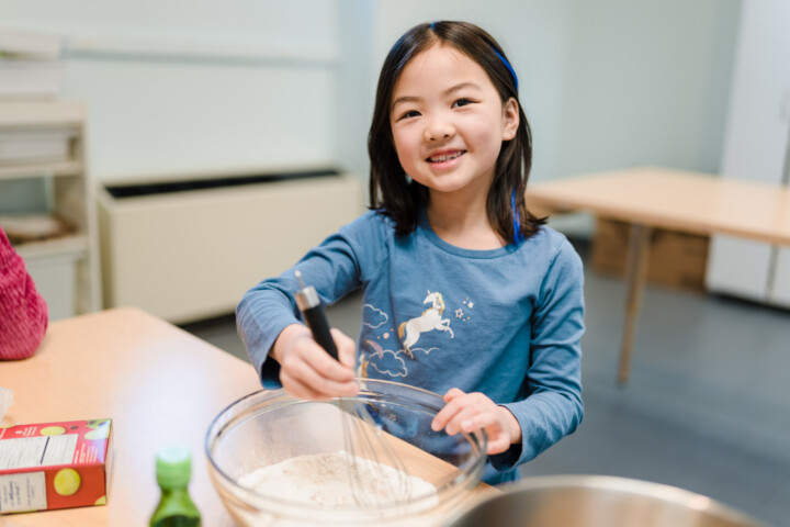 Girl smiling while baking.