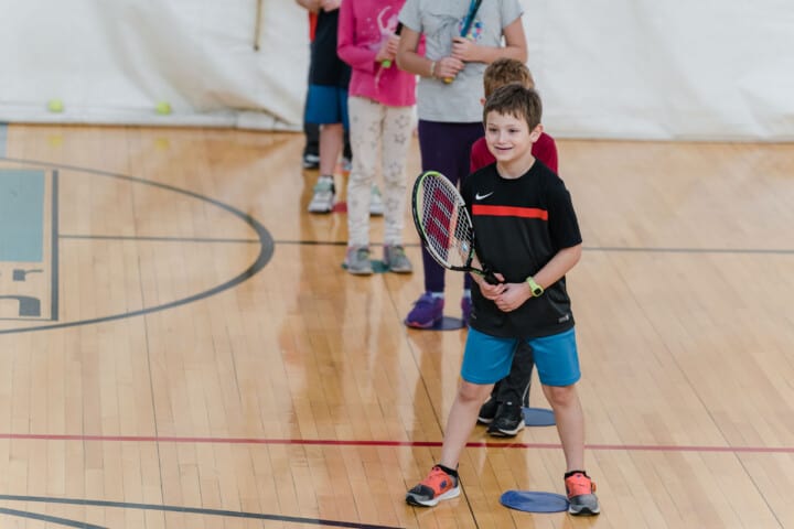 Boy playing tennis indoors at JCC Greater Boston.