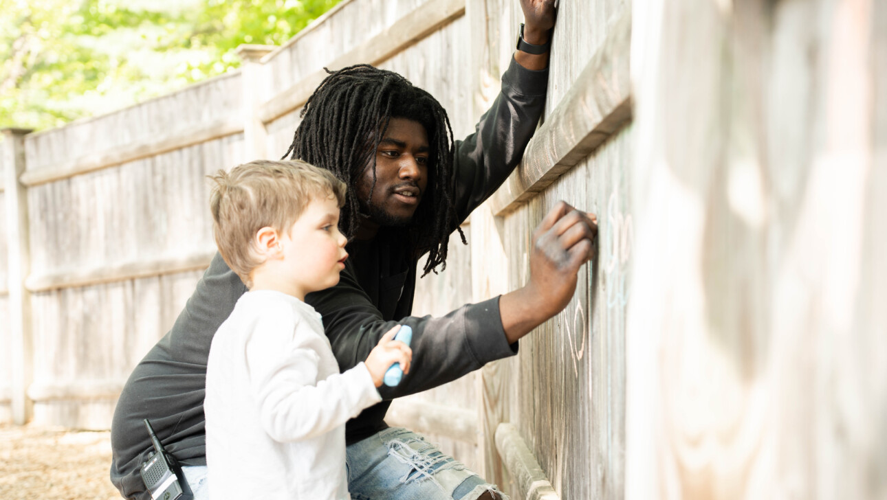 Child and teacher outside on the playground.