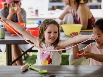Girl playing with slime outdoors at camp.