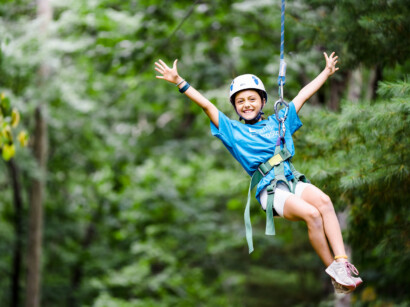 A camper riding a zipline.