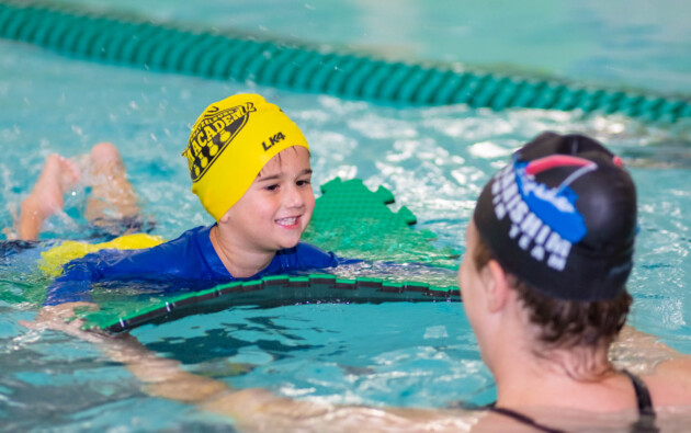 A young boy learning how to swim.