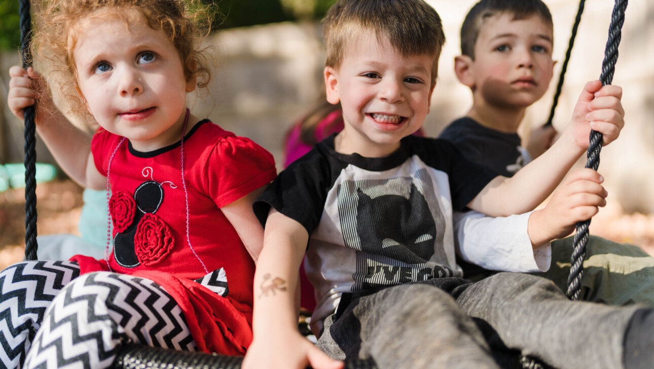 Three happy children playing outside.