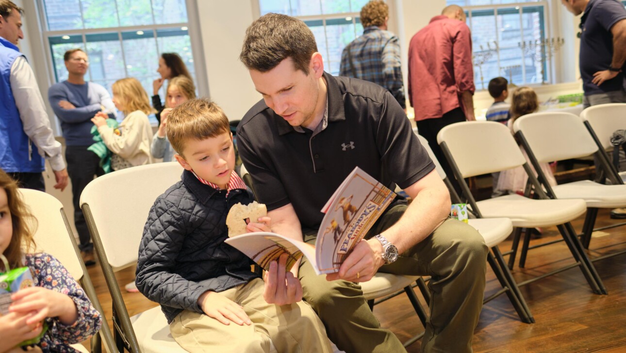 A father reading a book to his son.