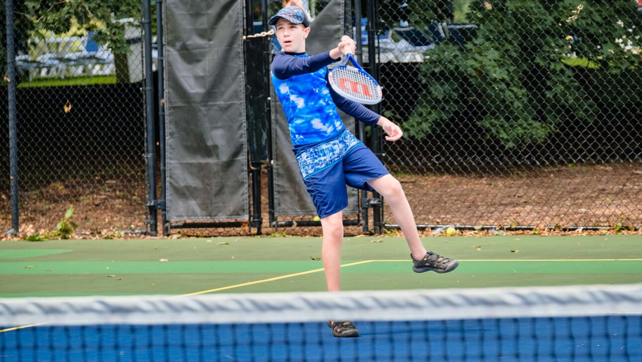 Boy playing tennis.