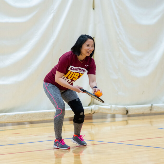 A woman playing pickleball.