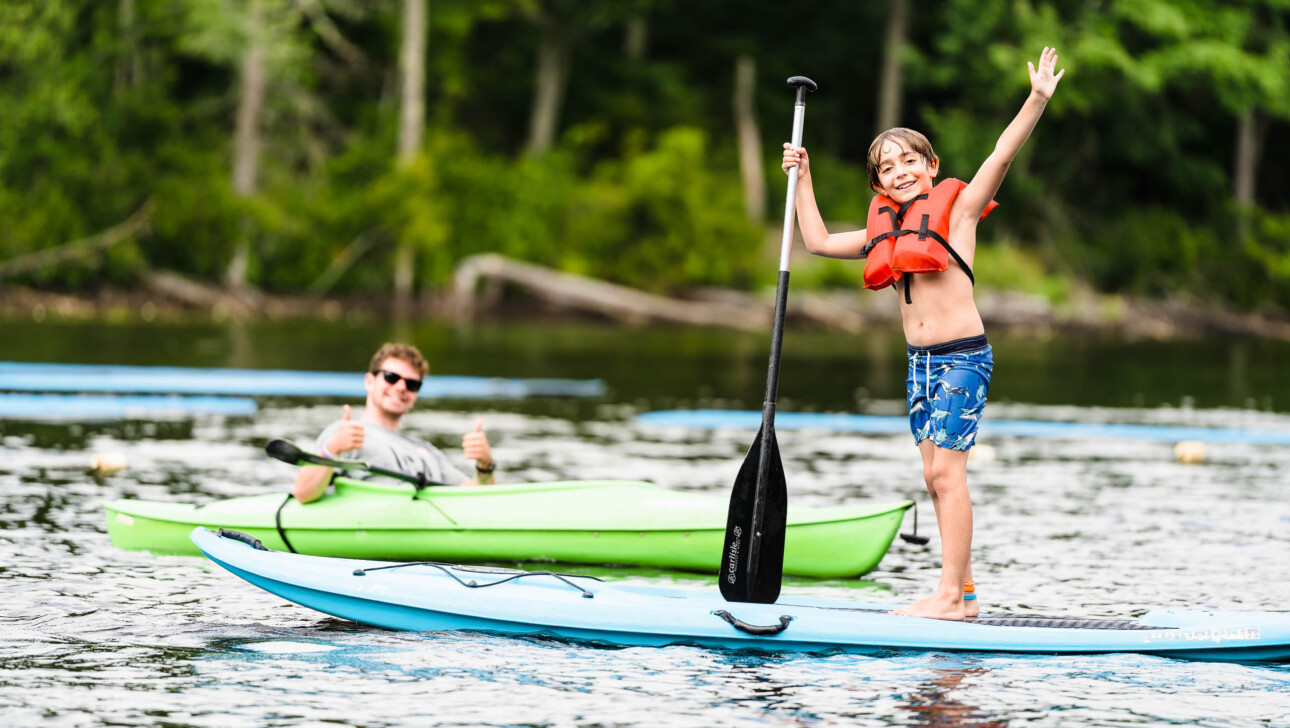 Kids posing on paddleboard.