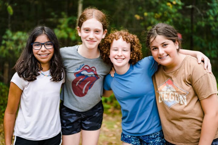 Girls smiling at the lakefront at Camp Grossman.