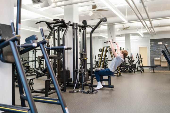 Man strength training in gym.