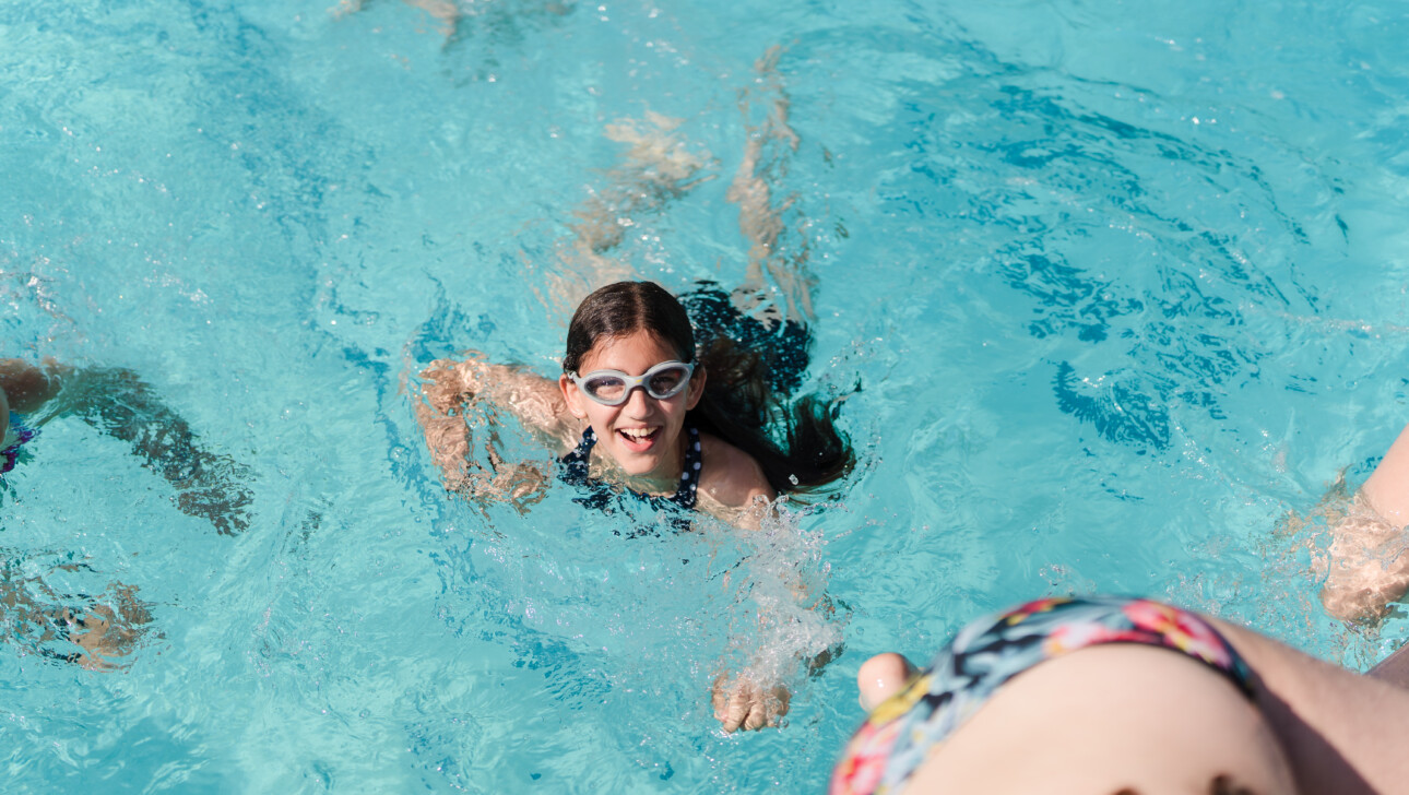 Girl smiling in a pool.