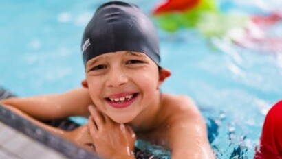 Boyy smiling in the pool.