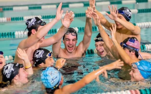 Group of teens cheering in the pool.