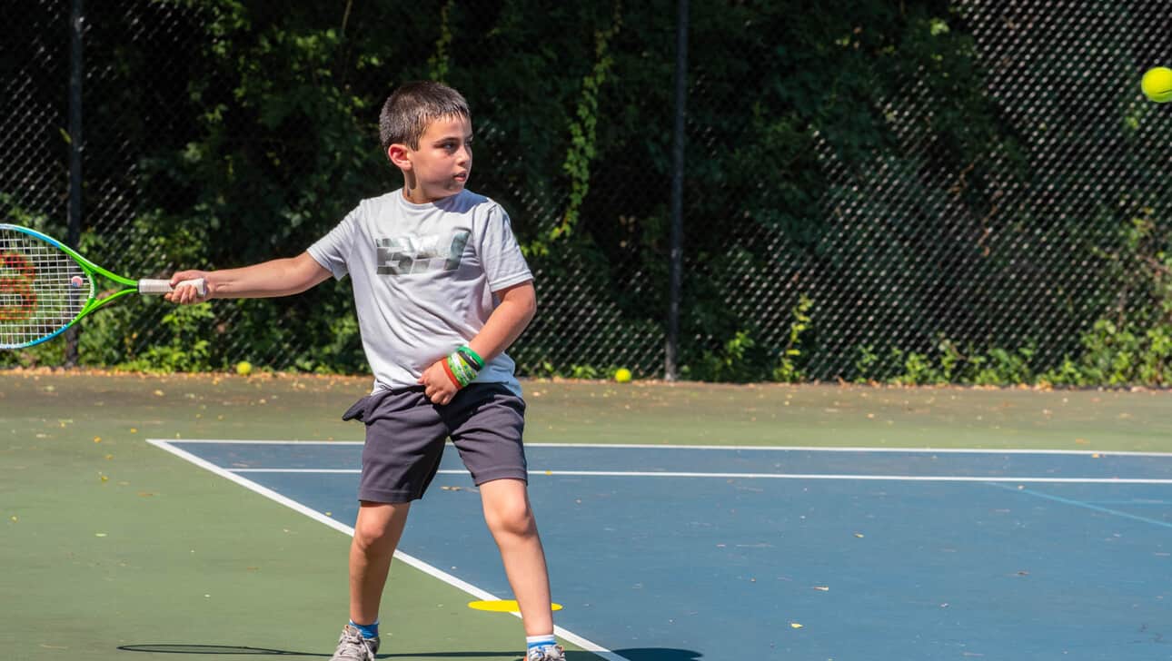 A boy playing tennis.