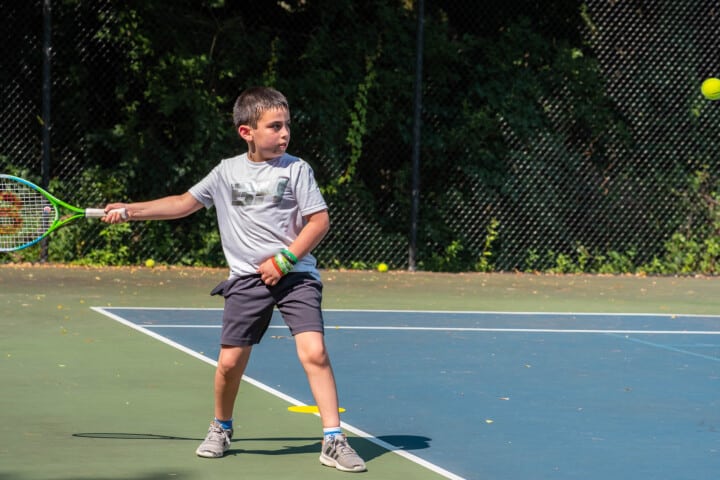 A boy playing tennis.