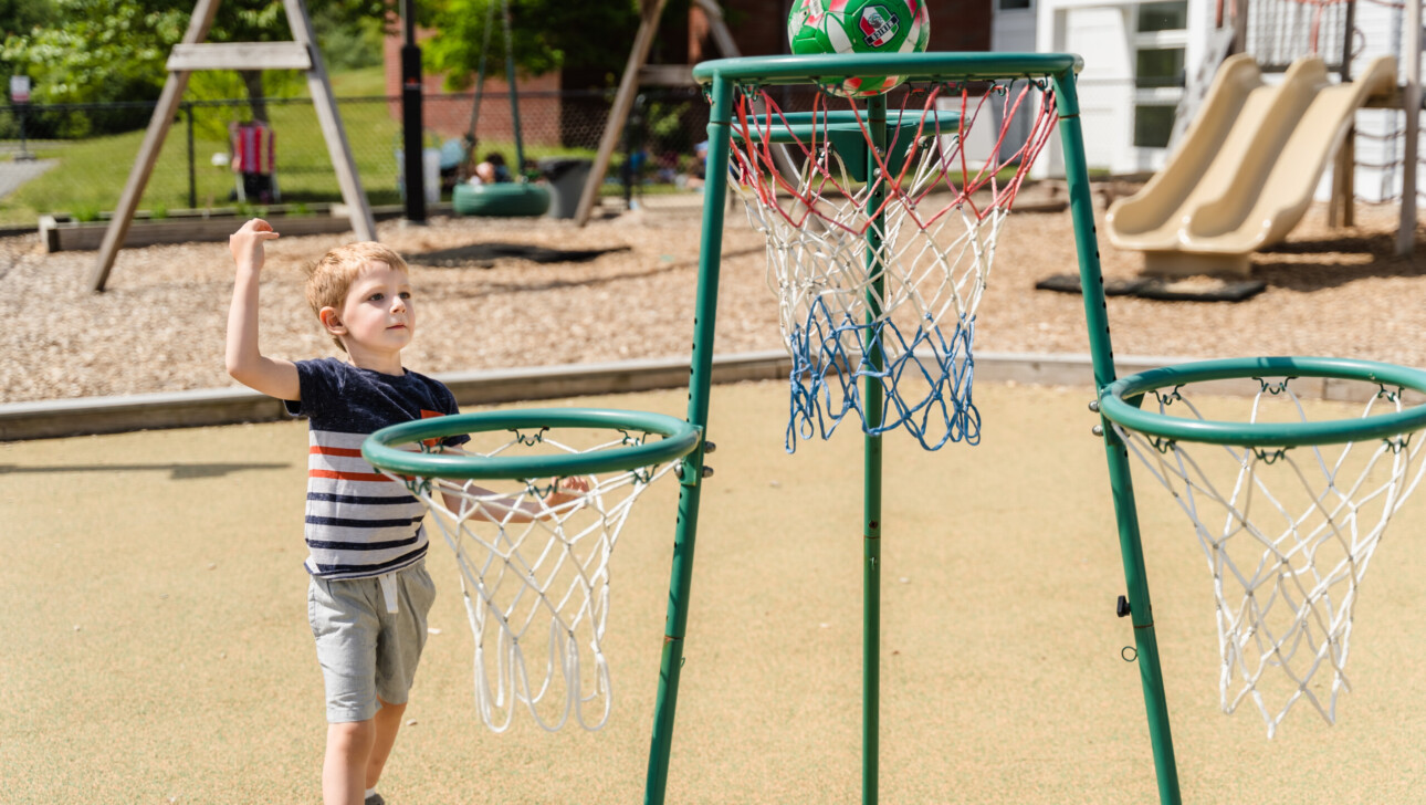 Kid playing with ball on the playground.