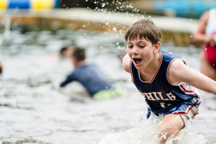 Boy running into the water at Camp Grossman.