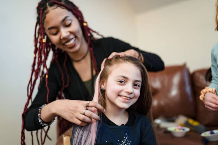 Girl smiling while getting her hair done.