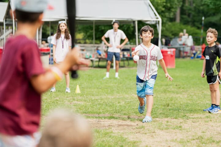 Kids playing wiffleball at camp.