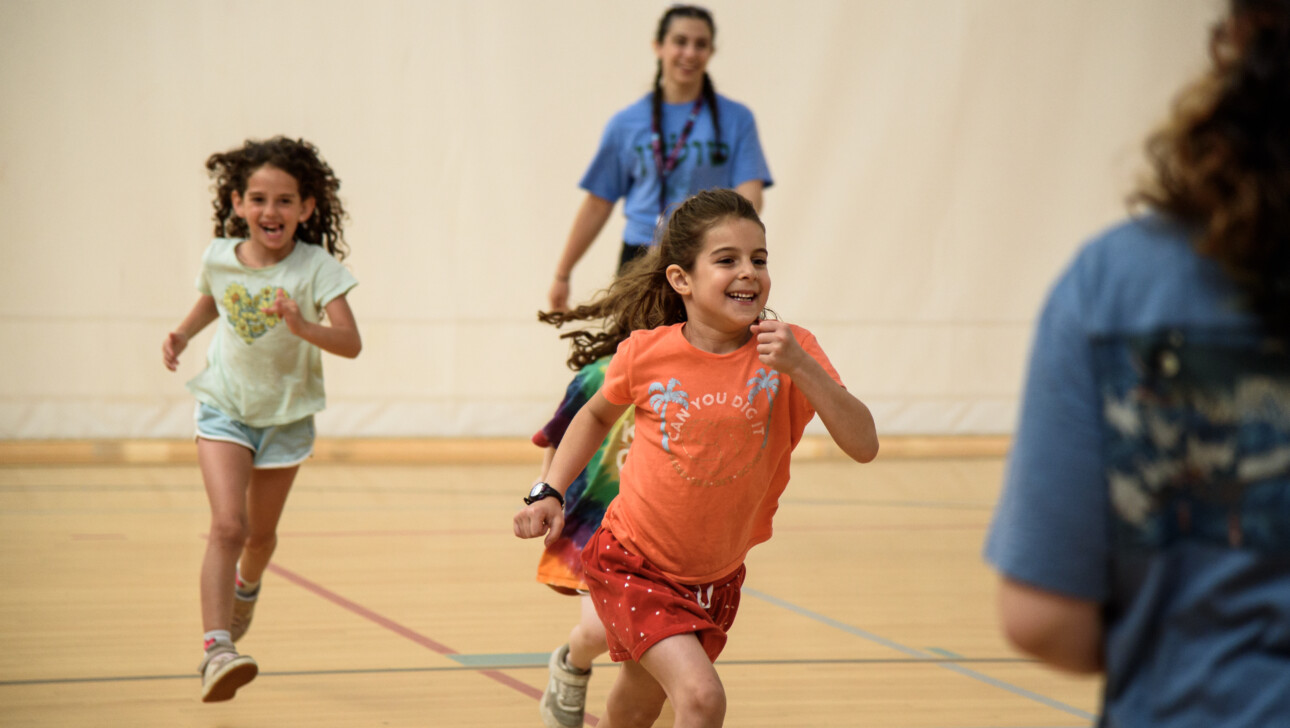 Girls running indoors at camp.