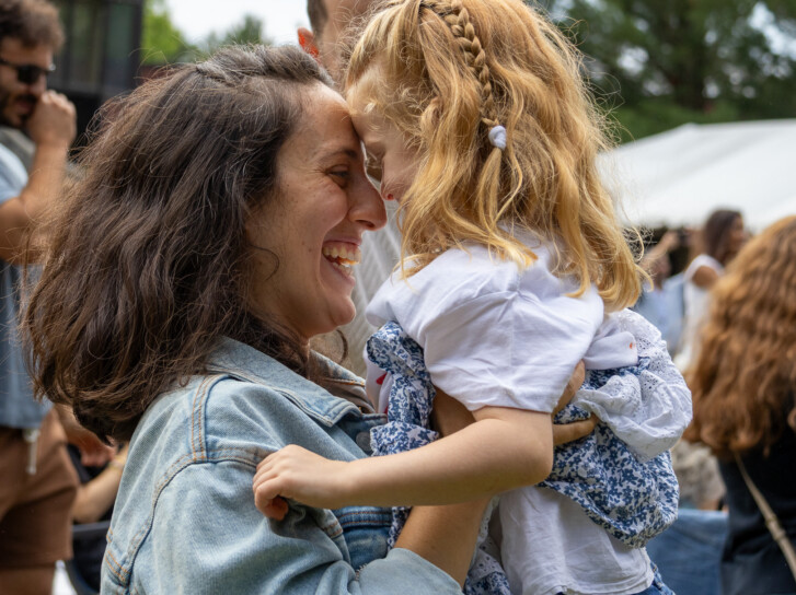 Godine student and mother hugging at graduation.